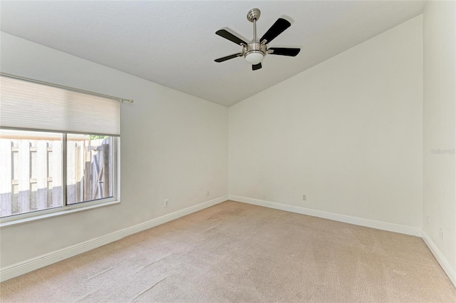 spare room with ceiling fan, light colored carpet, and lofted ceiling