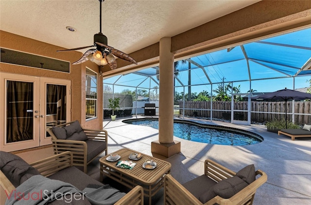 view of swimming pool with a patio, ceiling fan, and glass enclosure