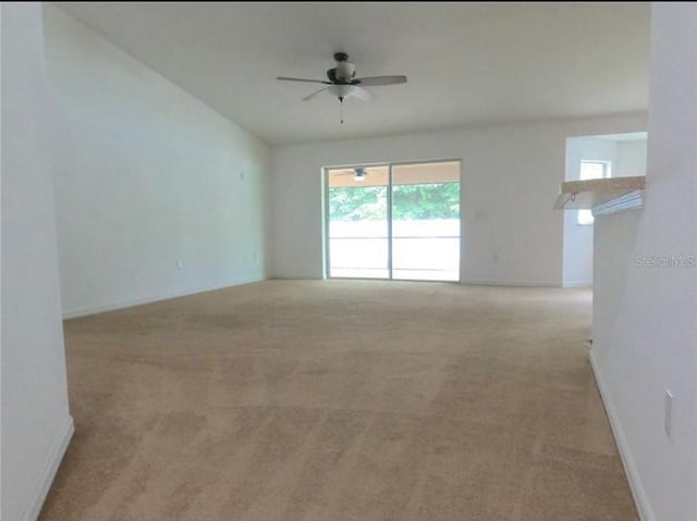 carpeted spare room featuring ceiling fan