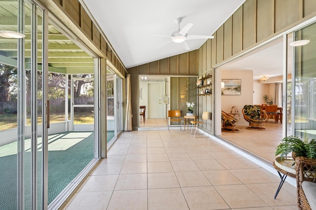 unfurnished sunroom with ceiling fan, vaulted ceiling, and a wealth of natural light