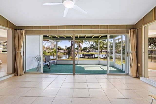 interior space with a water view and ceiling fan