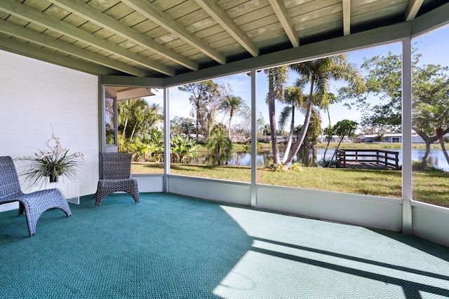 sunroom / solarium featuring a water view and beam ceiling