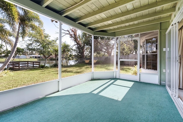 unfurnished sunroom featuring beam ceiling