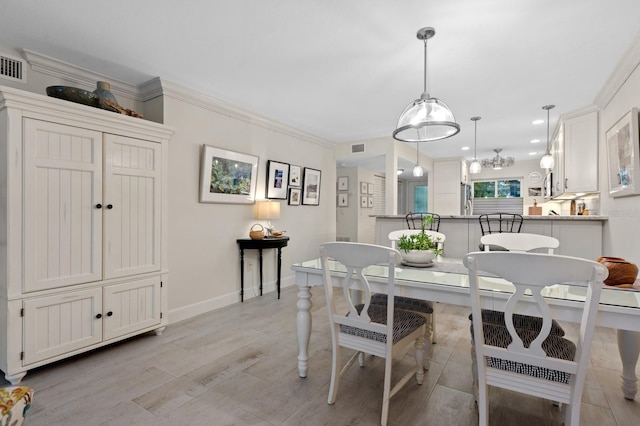 dining space featuring crown molding and light hardwood / wood-style flooring