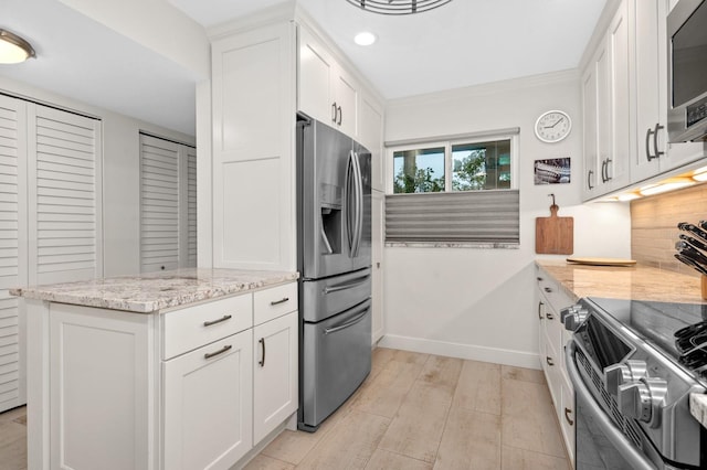 kitchen with tasteful backsplash, white cabinetry, kitchen peninsula, stainless steel appliances, and light stone countertops