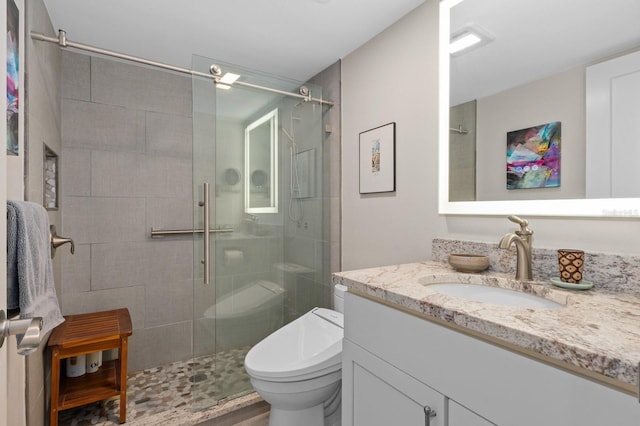 bathroom featuring vanity, toilet, and an enclosed shower