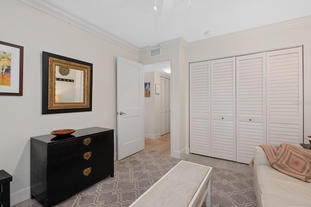 bedroom with crown molding, light hardwood / wood-style flooring, and a closet