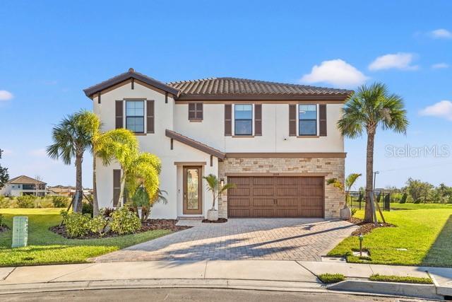 mediterranean / spanish house with a front yard and a garage