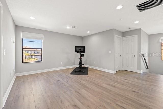 exercise area with light hardwood / wood-style floors