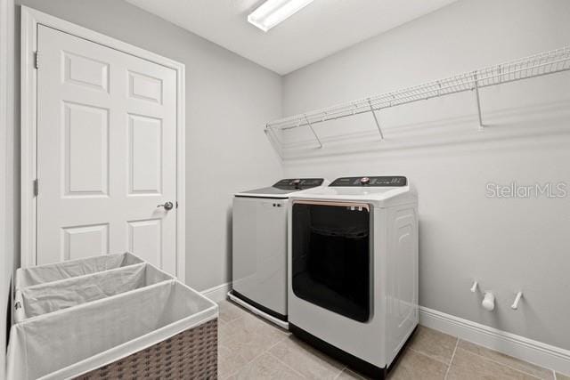 washroom with separate washer and dryer and light tile patterned flooring