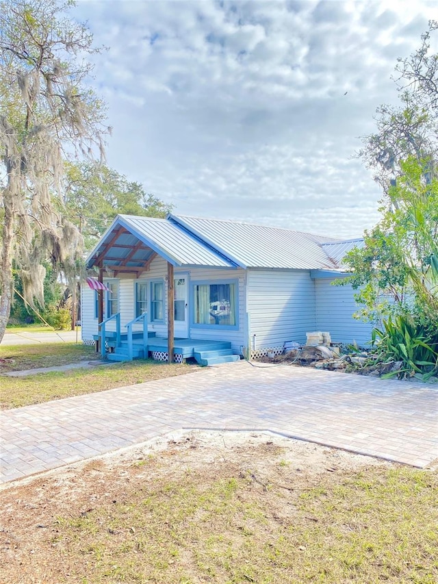 view of front of house featuring covered porch and a front lawn