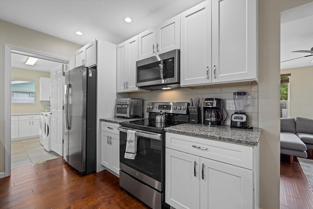 kitchen featuring a healthy amount of sunlight, appliances with stainless steel finishes, decorative backsplash, and washer and dryer