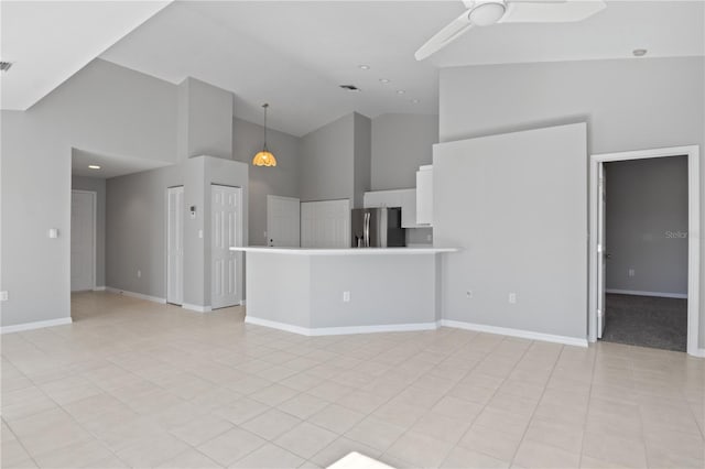 unfurnished living room with light tile patterned flooring, ceiling fan, and high vaulted ceiling