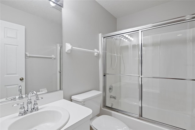 full bathroom with toilet, vanity, a textured ceiling, and shower / bath combination with glass door