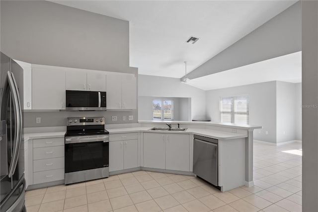 kitchen featuring vaulted ceiling, appliances with stainless steel finishes, sink, white cabinets, and kitchen peninsula