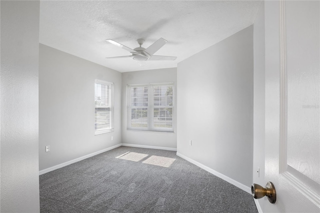 carpeted empty room with ceiling fan and a textured ceiling