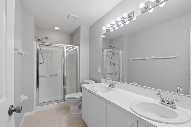 bathroom with toilet, vanity, tile patterned floors, and walk in shower