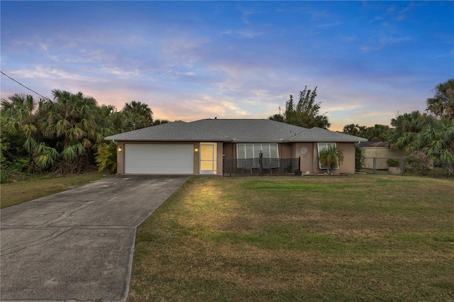 view of front of house featuring a garage and a lawn