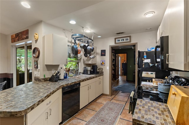 kitchen featuring sink, kitchen peninsula, white cabinets, and black appliances