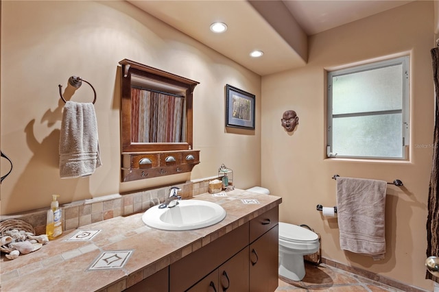 bathroom with tasteful backsplash, vanity, and toilet