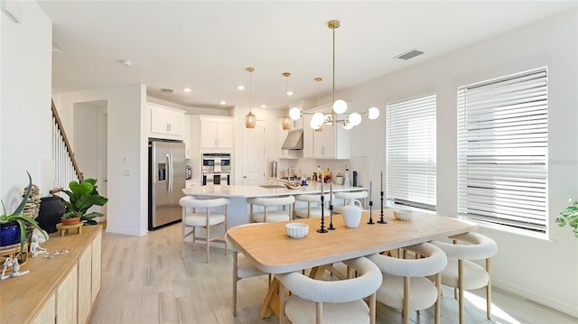 dining room with recessed lighting, a notable chandelier, visible vents, stairway, and light wood-type flooring