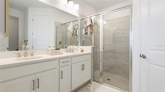 bathroom with marble finish floor, a sink, a shower stall, and double vanity