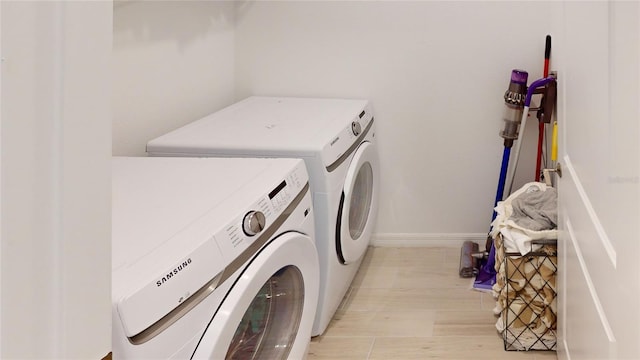 clothes washing area with laundry area, washer and clothes dryer, and baseboards