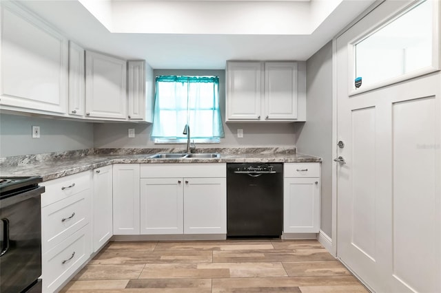 kitchen with black dishwasher, sink, white cabinets, and range