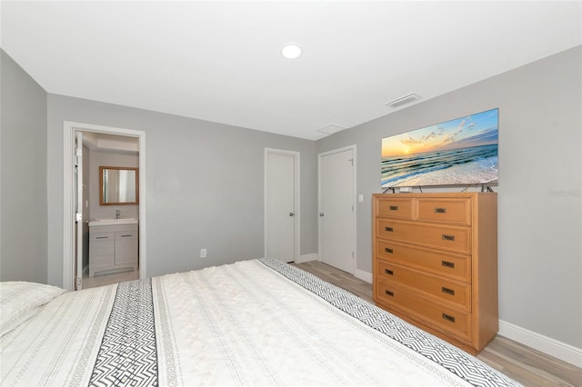 bedroom featuring ensuite bath and sink