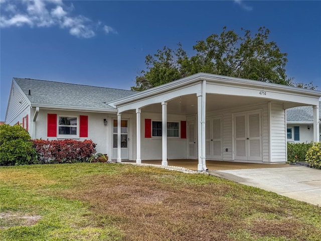 view of front of property with a carport and a front lawn