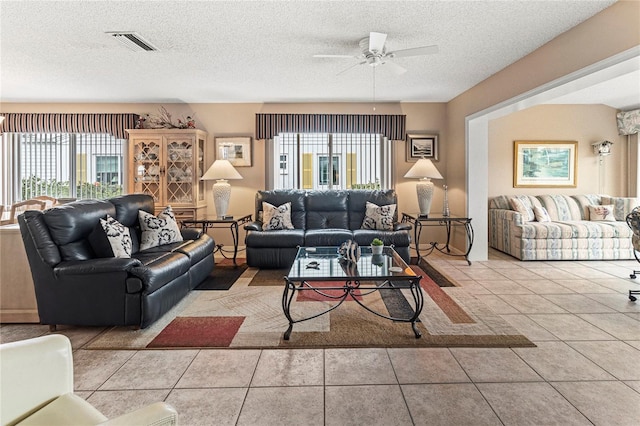 living room featuring plenty of natural light, light tile patterned floors, and a textured ceiling