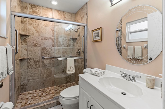 bathroom featuring vanity, toilet, and an enclosed shower