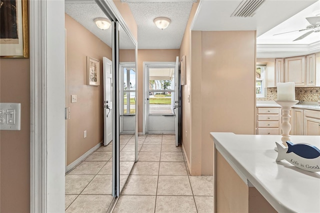 interior space with light tile patterned floors, a textured ceiling, and ceiling fan