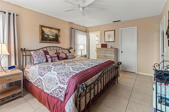 tiled bedroom featuring a textured ceiling and ceiling fan