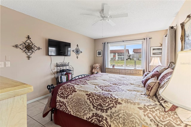 bedroom with light tile patterned floors, a textured ceiling, and ceiling fan