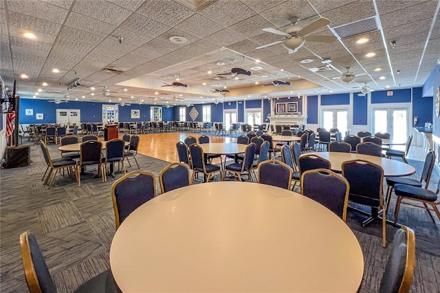 carpeted dining area featuring a ceiling fan, a paneled ceiling, and visible vents