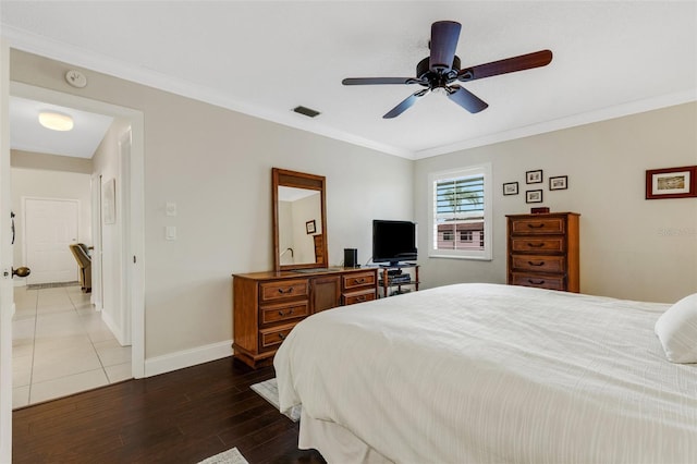 bedroom featuring ceiling fan, crown molding, and dark wood-type flooring