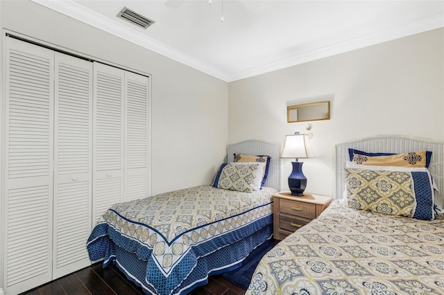 bedroom with ceiling fan, dark wood-type flooring, a closet, and ornamental molding