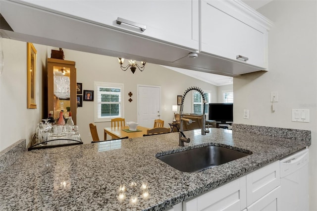 kitchen featuring sink, vaulted ceiling, white cabinetry, and dishwasher