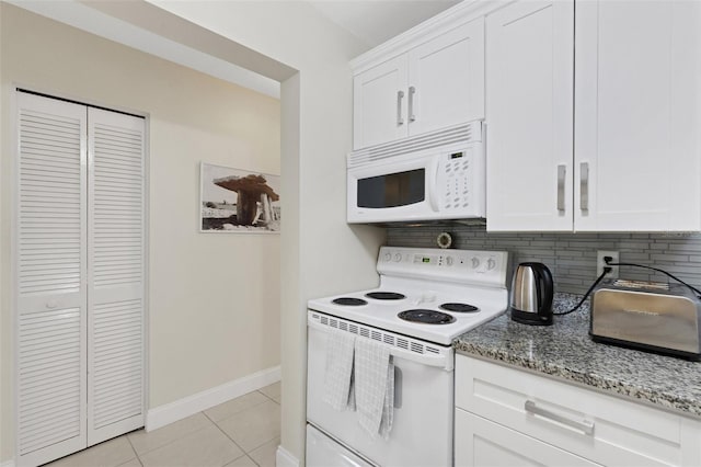 kitchen with white cabinets, tasteful backsplash, light tile patterned floors, light stone counters, and white appliances