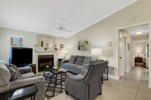 tiled living room featuring a tile fireplace, vaulted ceiling, ceiling fan, and ornamental molding