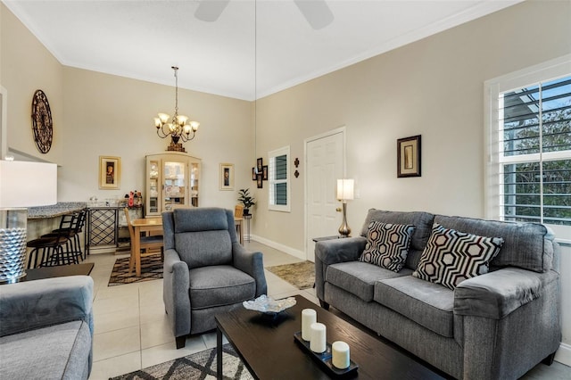 living room with ceiling fan with notable chandelier, light tile patterned floors, and ornamental molding