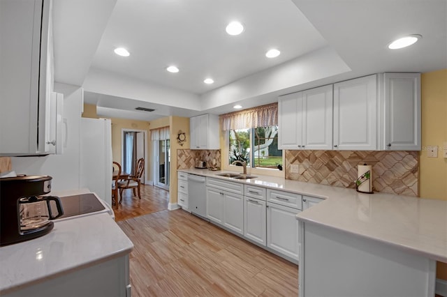 kitchen with white cabinetry, sink, white appliances, and light hardwood / wood-style floors