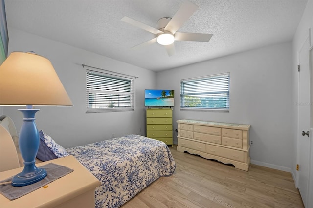 bedroom featuring a textured ceiling, light hardwood / wood-style floors, and ceiling fan