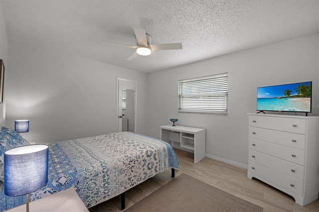 bedroom featuring a textured ceiling, light hardwood / wood-style floors, and ceiling fan