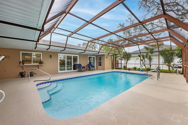 view of swimming pool featuring a patio and a lanai