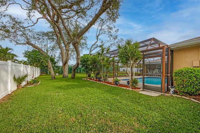 view of yard featuring a fenced in pool and glass enclosure