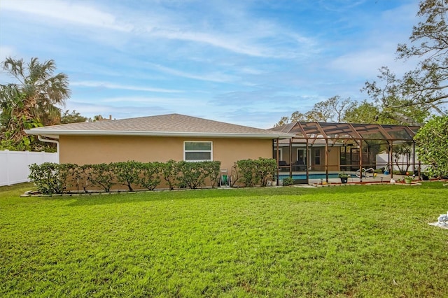 back of house featuring a swimming pool, a lawn, and glass enclosure