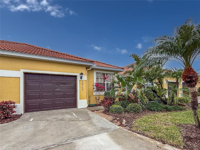 5715 Spanish Point Ct, Palmetto, FL 34221 - view of front of home with stucco siding, a tile roof, concrete driveway, and an attached garage