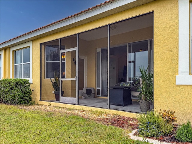 back of property featuring a yard and a sunroom